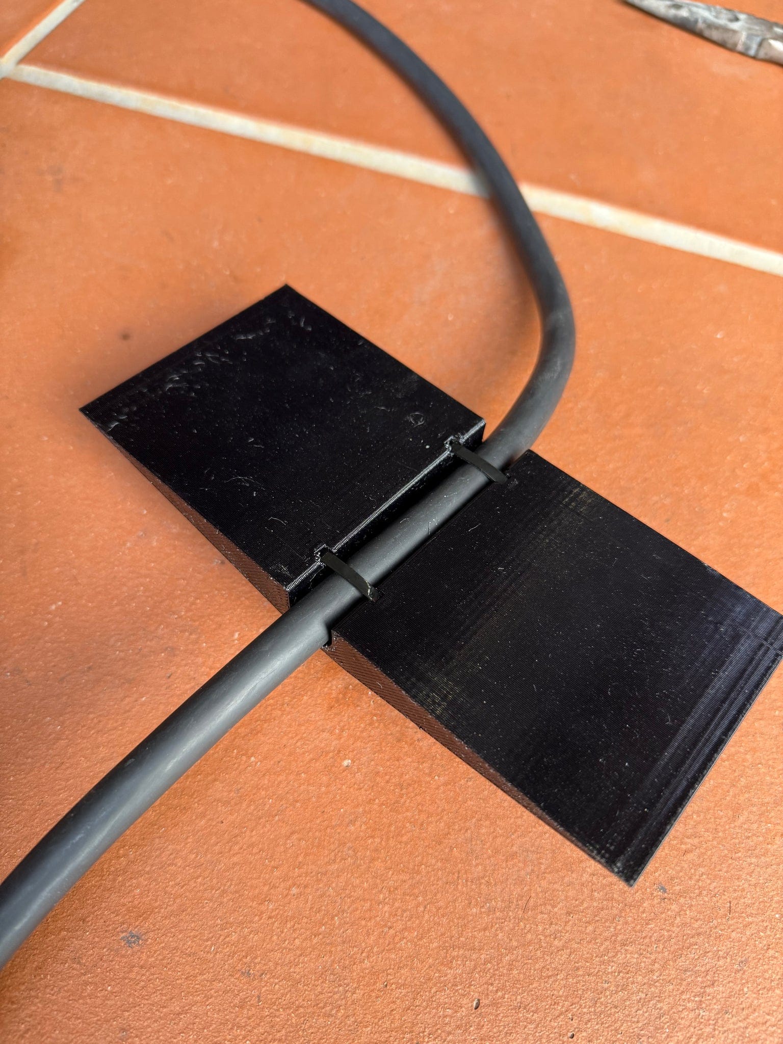 Center-wedge EV charging cable garage door pass-through protector