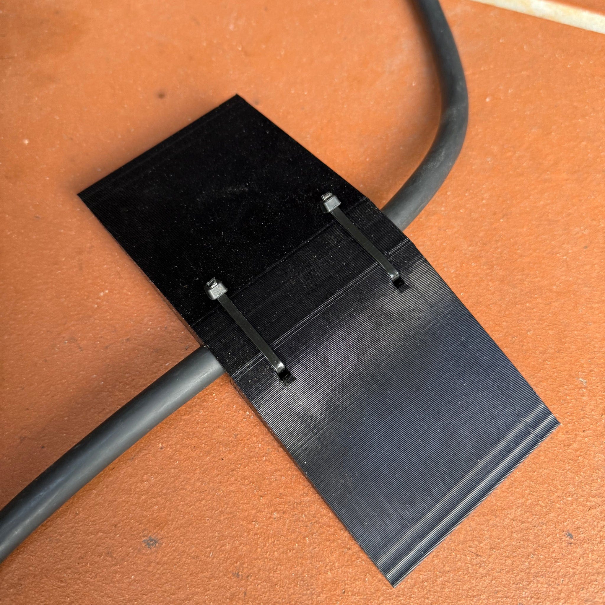 Center-wedge EV charging cable garage door pass-through protector