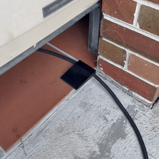 Side-mount EV charging cable garage door pass-through protector