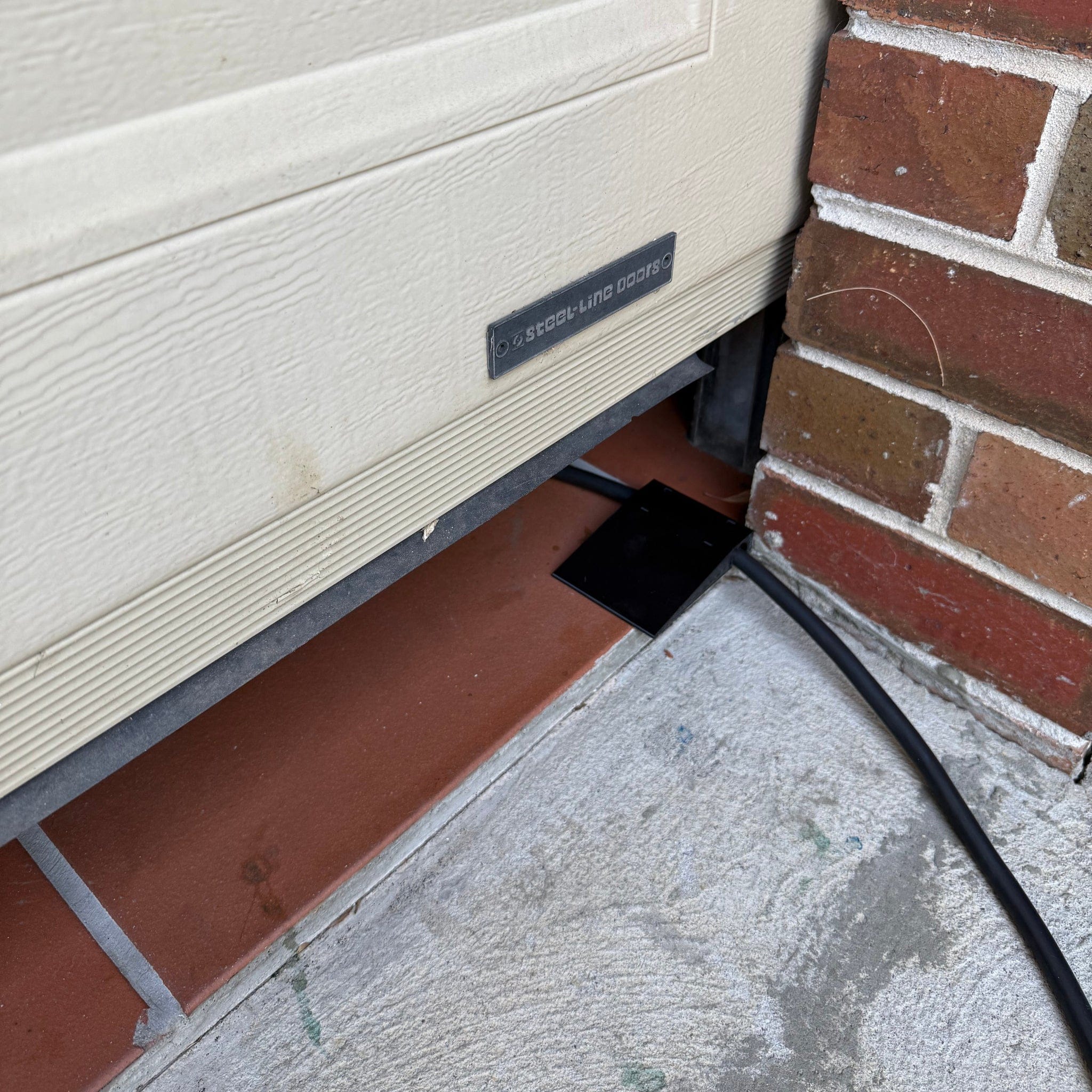 Side-mount EV charging cable garage door pass-through protector