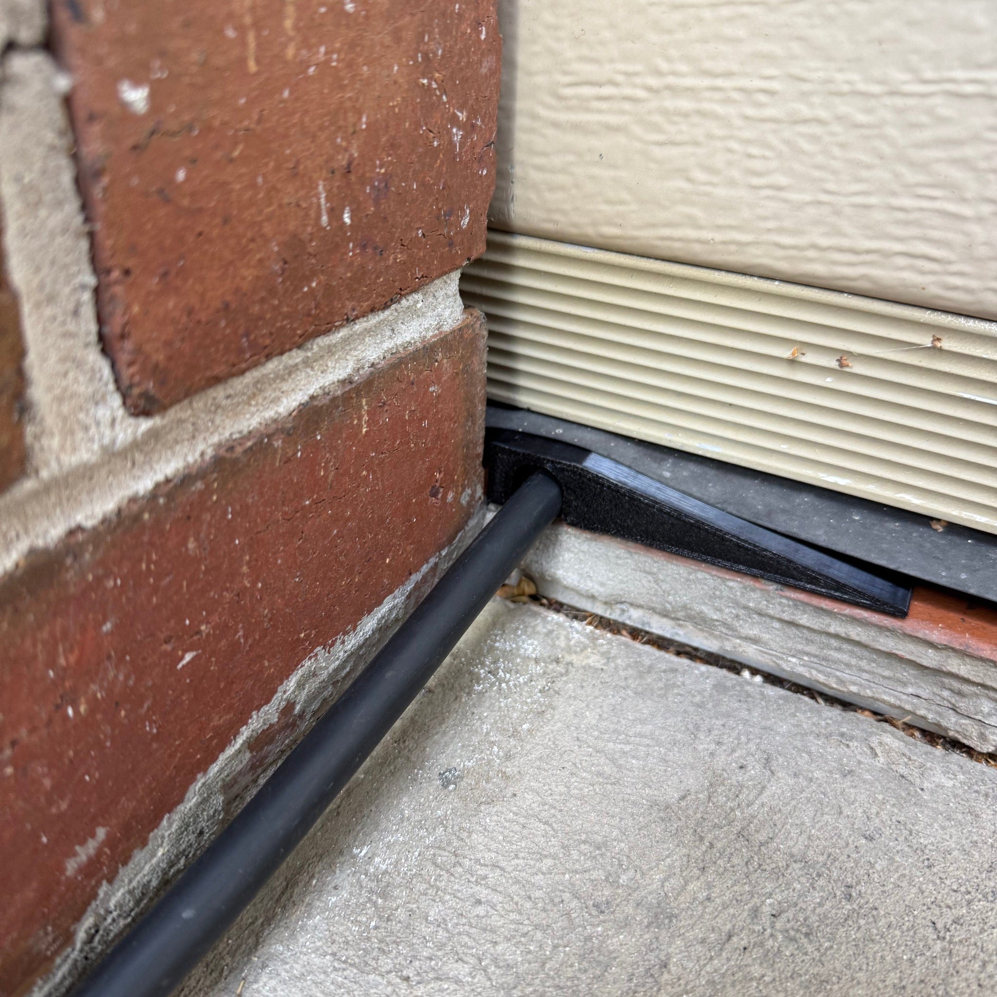 Side-mount EV charging cable garage door pass-through protector