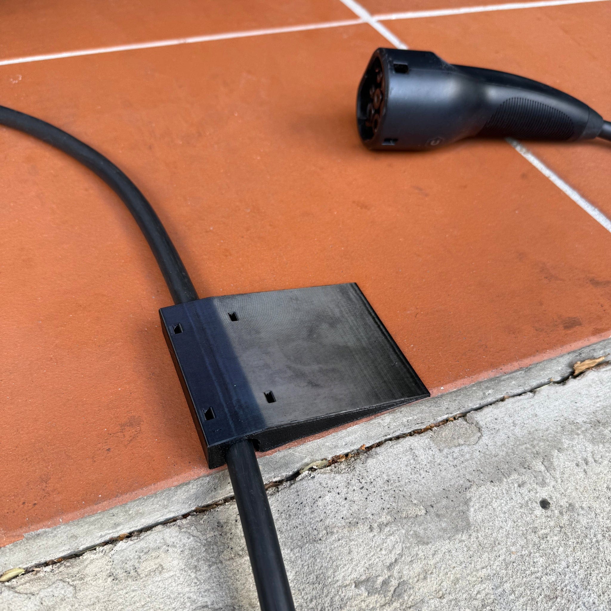 Side-mount EV charging cable garage door pass-through protector